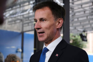 Jeremy Hunt is to delay a penny cut in income tax, the flagship announcement in the disastrous mini-budget, to help plug a black hole in the public finances that had reached £72 billion.
